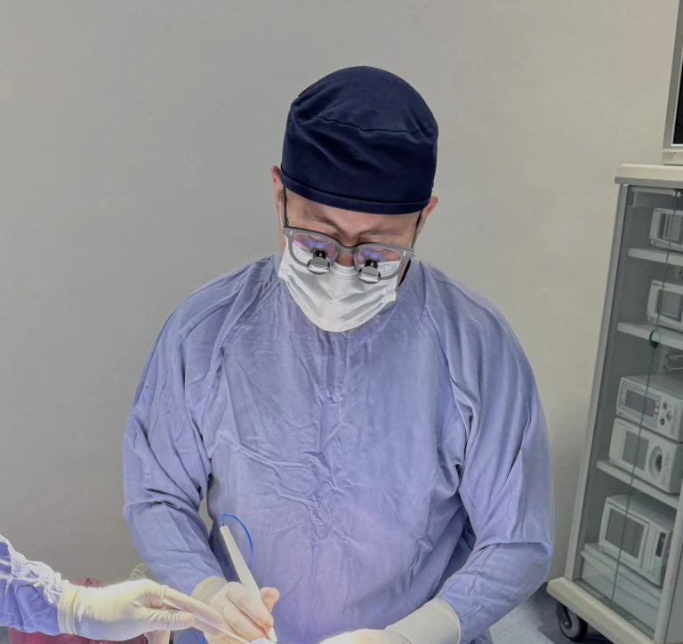 Dr. Iván De León trabajando con una asistente quirúrgica en el quirófano